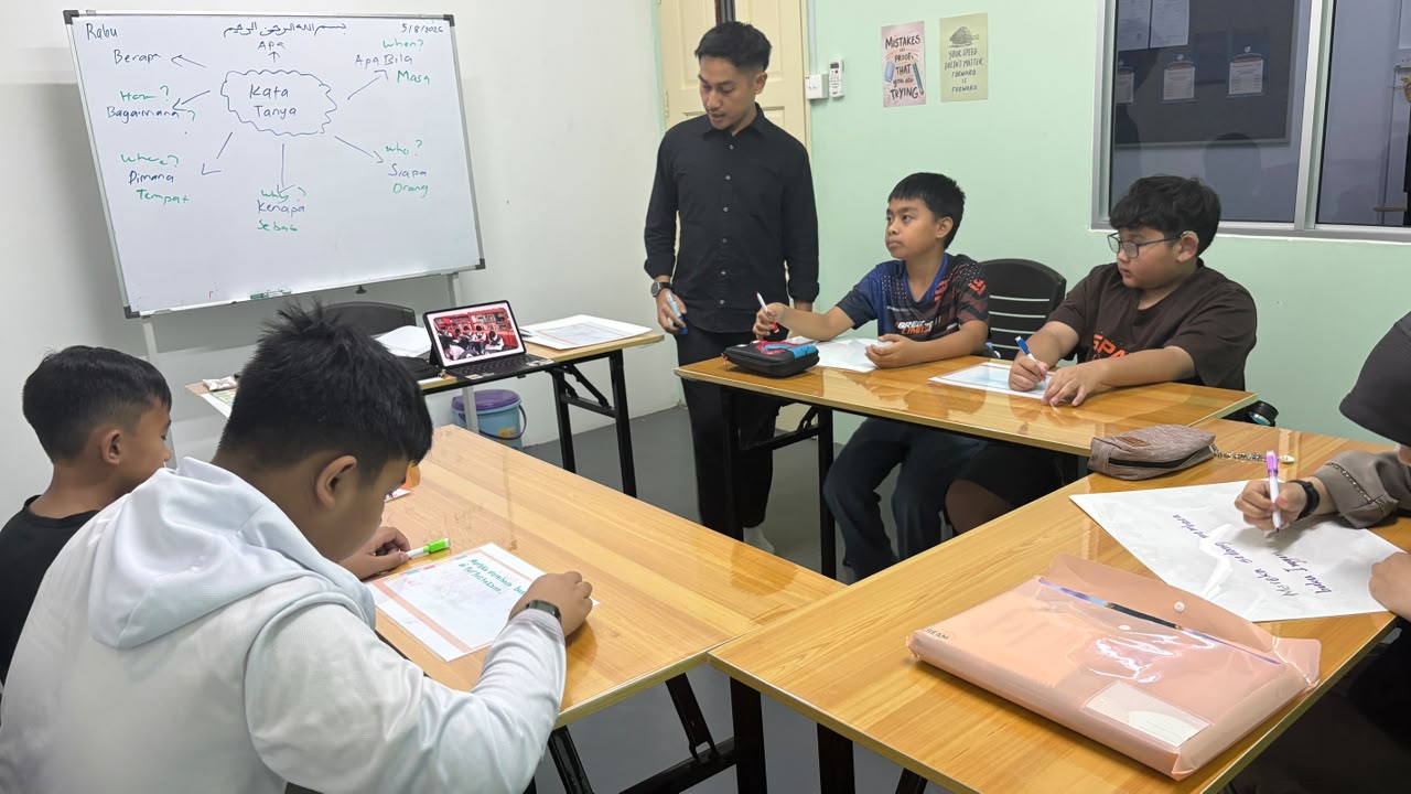 An AFTC tutor helping students with a Bahasa Melayu lesson